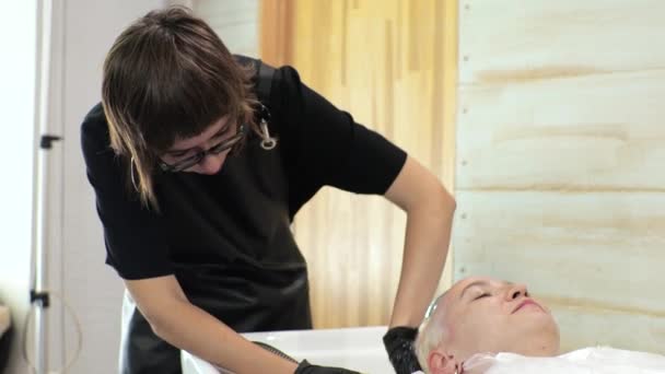 Peluquería lava el tinte del pelo de las mujeres. El salón está en casa.. — Vídeos de Stock