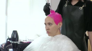 Kuaför kadınların saçlarını pembeye boyar. Salgın sırasında ev salonu. LGBT
