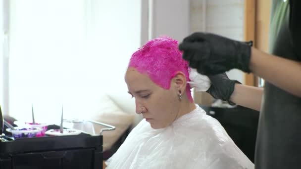 Penata rambut mewarnai wanita berambut merah muda. Salon rumah selama epidemi. LGBT dengan topeng di wajahku. — Stok Video