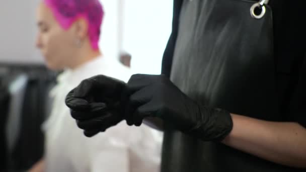 Le coiffeur enlève les gants en latex noir. Le salon est à la maison. — Video