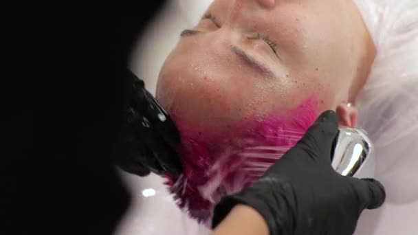 De kapper wast een vrouwenhaar van een roze kleurstof. Huis salon tijdens de epidemie. — Stockvideo