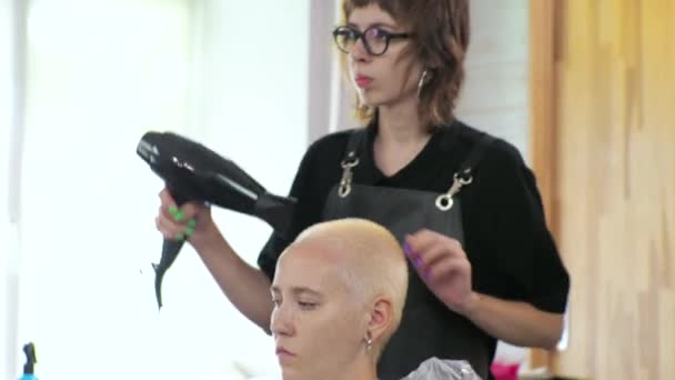 Coiffeur sèche les cheveux des femmes. Le salon est à la maison. — Video