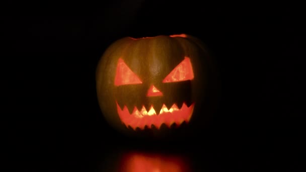 La donna si mette una maschera protettiva dal virus su una zucca ad Halloween. Isolato sfondo nero. — Video Stock