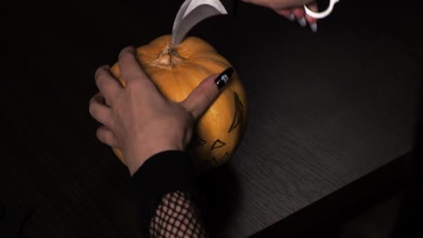 Mujer joven prepara una calabaza para Halloween. Corta el interior. Vacaciones. — Vídeo de stock