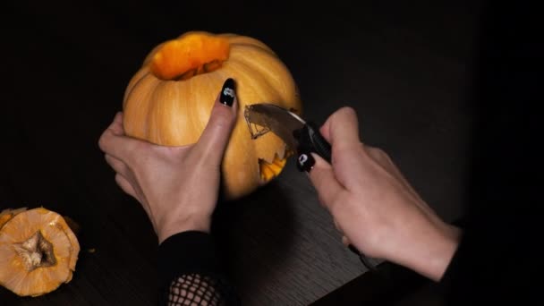 La giovane donna prepara una zucca per Halloween. Taglia gli occhi. Celebrazione — Video Stock