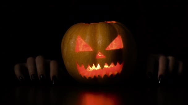 Молодая женщина валяет дурака с тыквой Хэллоуин праздник изолированный черный фон. — стоковое видео
