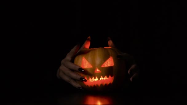 Mladá žena pohrává s dýní Halloween dává strašidelné rohy Izolované černé pozadí — Stock video