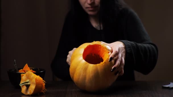 Mladá brunetka žena vyřezává dýni na Halloween Příprava na dovolenou — Stock video