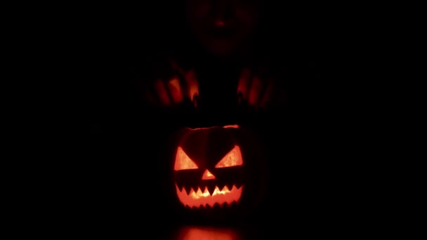 Mujer joven jugando con una calabaza Halloween da cuernos espeluznantes Fondo negro aislado — Vídeos de Stock