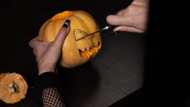 Mladá žena připravuje dýni na Halloween. Vyřízne ti oči. Oslava — Stock video