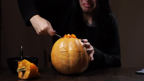Jovem morena esculpe uma abóbora para o Halloween Preparação para o feriado — Vídeo de Stock
