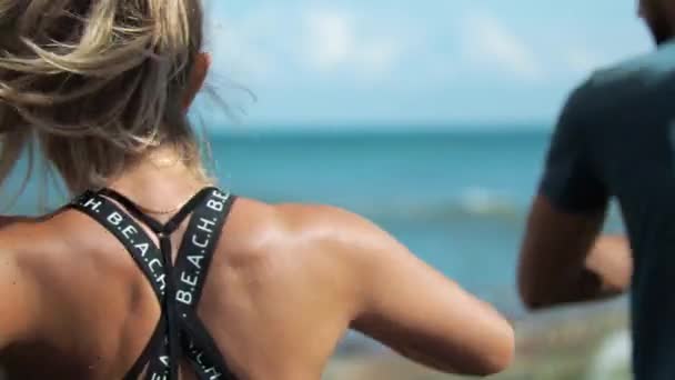 금발 여성이 코치와 해변에서 운동 할 준비를 하고 있습니다 — 비디오