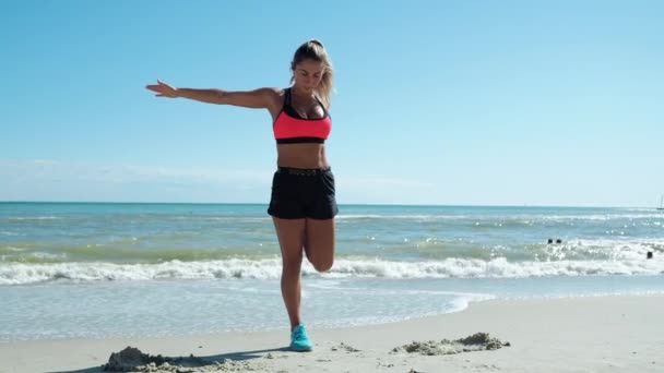 Crossfit Uma mulher loira está se aquecendo se preparando para um treino Na praia junto ao mar — Vídeo de Stock