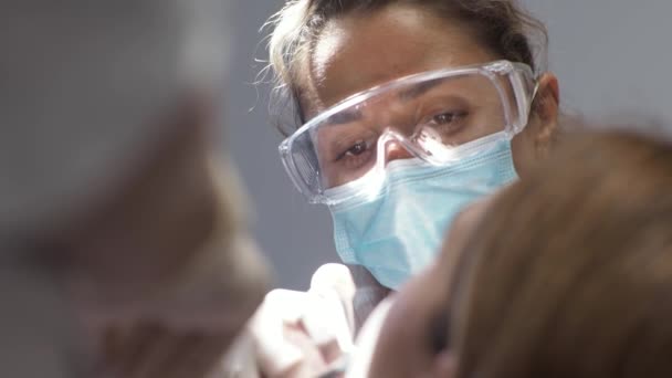 Ung kvinna tandläkare Mottagning på ortodontist Ersättning av tandställning Polering Gel bindning — Stockvideo