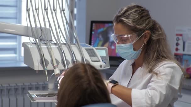 Diş hekimindeki genç bayan resepsiyon diş tellerinin değiştirilmesi jel cilalama — Stok video