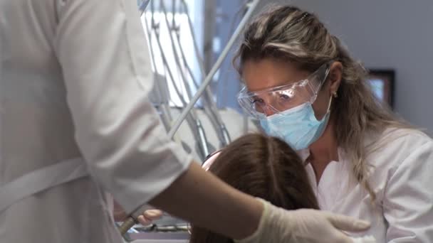 Ung kvinna tandläkare Mottagning på ortodontist Ersättning av tandställning Polering Gel bindning — Stockvideo