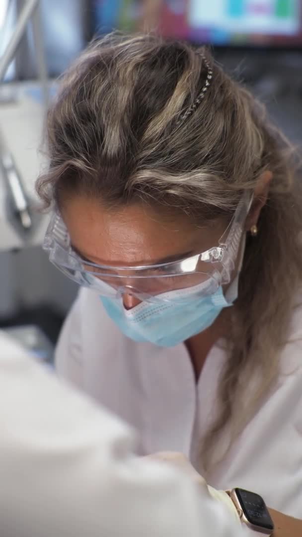 歯列矯正医での若い女性歯科医のレセプションブレースの交換研磨ジェル結合 — ストック動画
