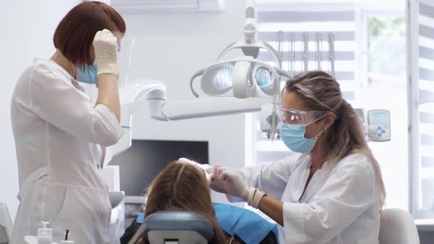 Mujer joven dentista Recepción en el ortodoncista Sustitución de los aparatos ortopédicos Puliendo la unión del gel — Vídeo de stock