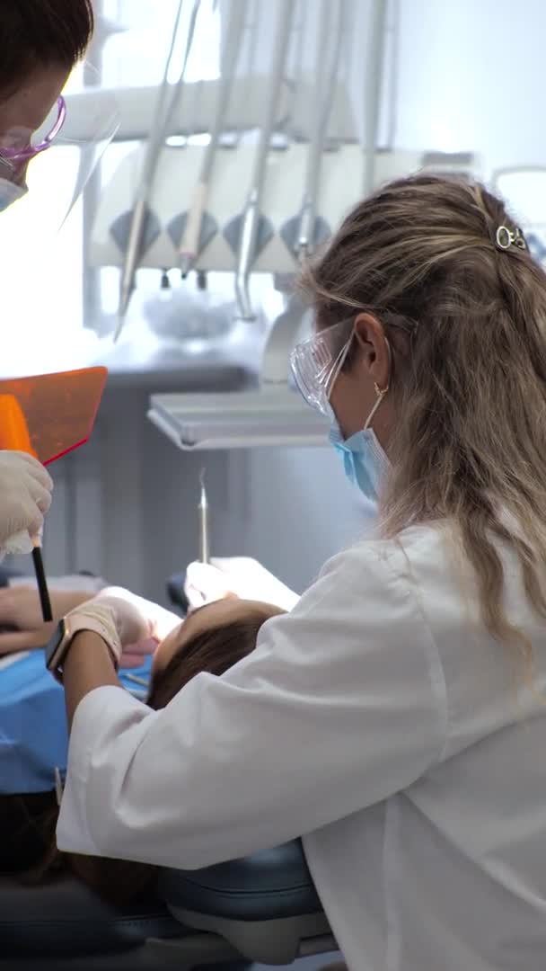 Mujer joven dentista Recepción en el ortodoncista Sustitución de los aparatos ortopédicos Puliendo la unión del gel — Vídeos de Stock