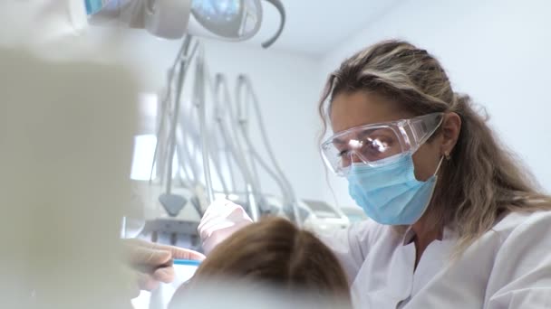 歯列矯正医での若い女性歯科医のレセプションブレースの交換研磨ジェル結合 — ストック動画