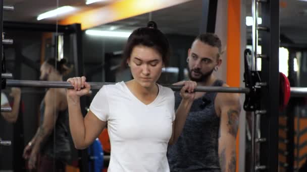 Tornaterem Vicces férfi edz egy törekvő fiatal nő tanít swing lábak guggolások motiválja — Stock videók