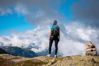 Uzun yürüyüşe çıkan kimse üstünde belgili tanımlık dağ tepe. Spor ve aktif bir yaşam kavramı. Trolltunga Norveç
