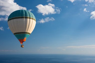kleurrijke hete lucht ballon vliegen over de blauwe zee