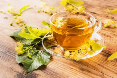 Fincan yeşil çay ve ıhlamur ahşap arka plan üzerinde