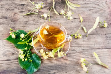 Fincan çay ve ıhlamur ahşap arka plan üzerinde