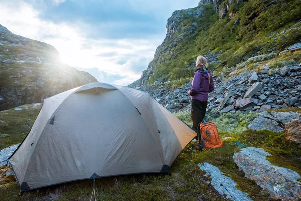 Barraca turística e mulher nas montanhas por do sol Noruega — Fotografia de Stock