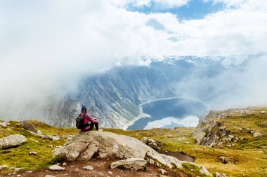 Uzun yürüyüşe çıkan kimse üstünde belgili tanımlık dağ tepe. Spor ve aktif bir yaşam kavramı. Trolltunga Norveç