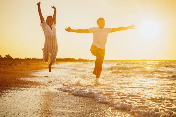 Happy couple running on the beach — Stock Photo, Image