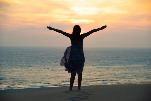 Silhouet van vrijheid en gelukkig meisje op het strand — Stockfoto