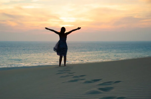 Silhouette der Freiheit und glückliches Mädchen am Strand — Stockfoto