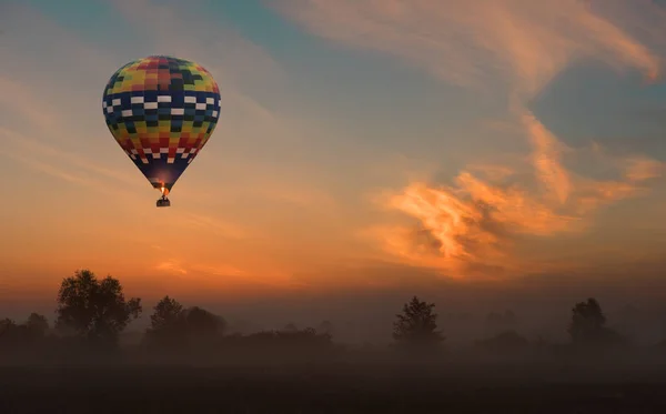 Воздушный шар летит на желтом восходе солнца — стоковое фото