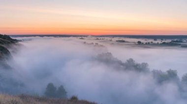 Nehir ve gündoğumu arka plan üzerinde çayır üzerinde curling Timelapse sis