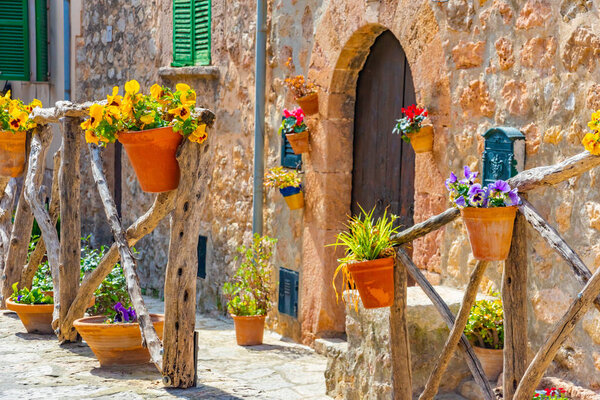 Beautiful window with flower pots and colorful flowers serving as a decoration of the facade. Spanish village Valldemossa, Mallorca, Spain