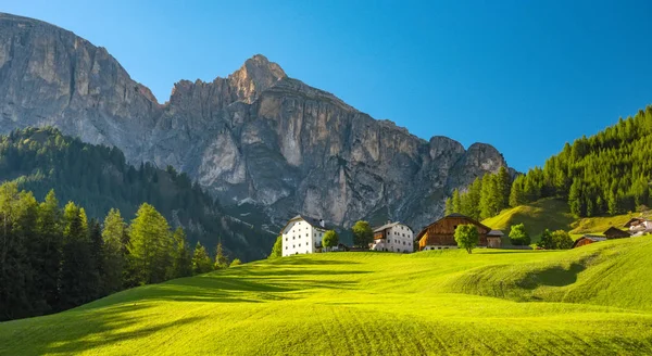 Pueblo de Corvara, pueblo alpino en los Alpes Dolimitas en el soleado día de verano, Italia —  Fotos de Stock