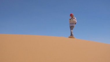 Sportif kadın Sahra çölü boyunca yürüyor