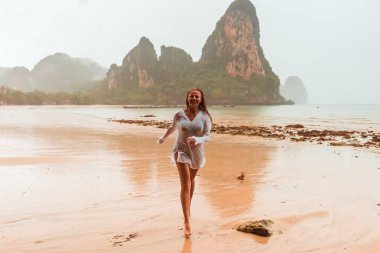 Kadının yağışlı tropikal beach Tayland düşmek