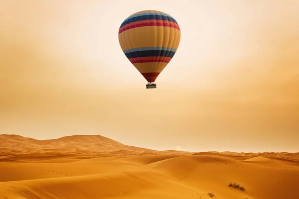 日出时的沙漠和热气球景观 图库照片