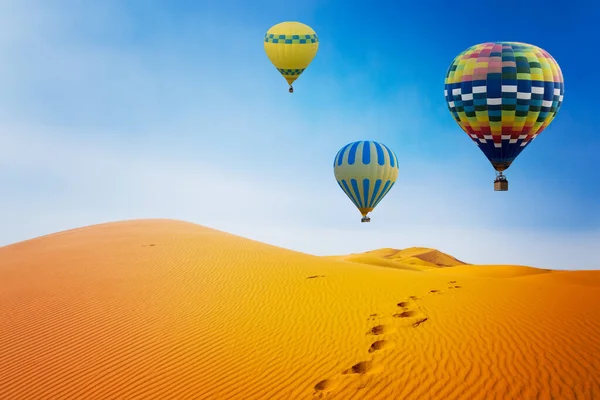 日出时的沙漠和热气球景观 免版税图库照片