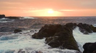 Okyanus dalgaları gün batımında kayalara çarpar Playa Benijo plajı, Tenerife, Kanarya