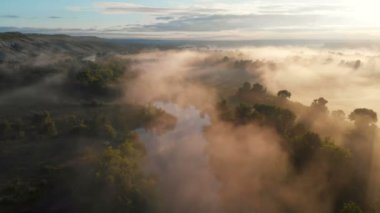 Güneşin sisli nehrin üzerinde doğuşunun hava aracı görüntüsü