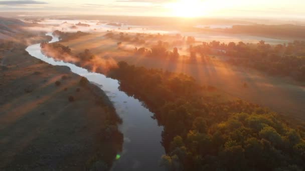 Dron powietrzny widok wschodu słońca nad mglistą rzeką — Wideo stockowe