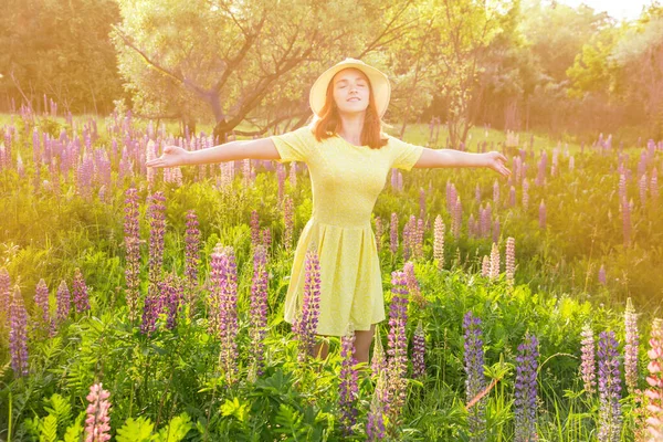 Menina adolescente feliz em chapéu no prado do por do sol florido — Fotografia de Stock