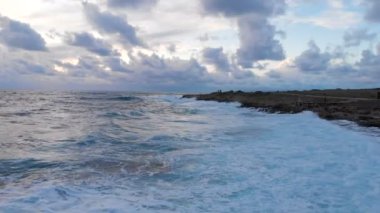 4k Havadan deniz dalgalarının görüntüsü taştan sahilde kırılıyor