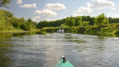 Yeşil yaz ormanlarında kano sakin bir nehirde yüzer.
