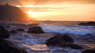 Okyanus dalgaları gün batımında kayalara çarpar Playa Benijo plajı, Tenerife, Kanarya