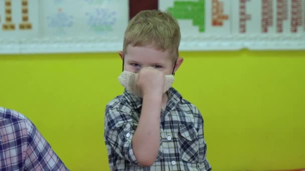 Mistura de 2 vídeos. Retrato de um menino com máscara facial médica em pé ao ar livre . — Vídeo de Stock